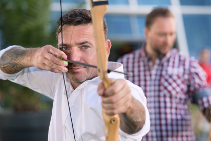 Mann zielt mit Pfeil und Bogen