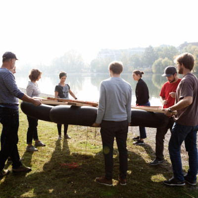 Gruppe bringt Floss ins Wasser