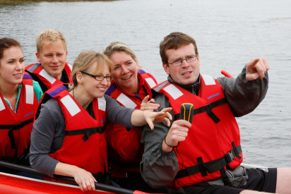 Menschen im Schlauchboot. Mann zeigt auf etwas.